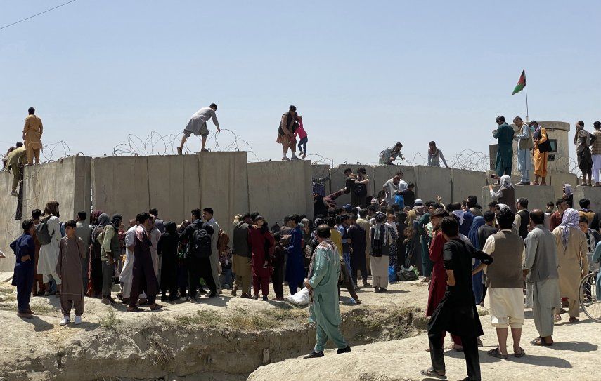 &nbsp;Afganos se agolpan a lo largo del muro del aeropuerto internacional Hamid Karzai antes de saltarlo en un intento de abandonar el país