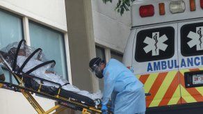 Personal de salud traslada a una persona contagiada con la COVID-19 en la zona de emergencias del Hospital General en México.