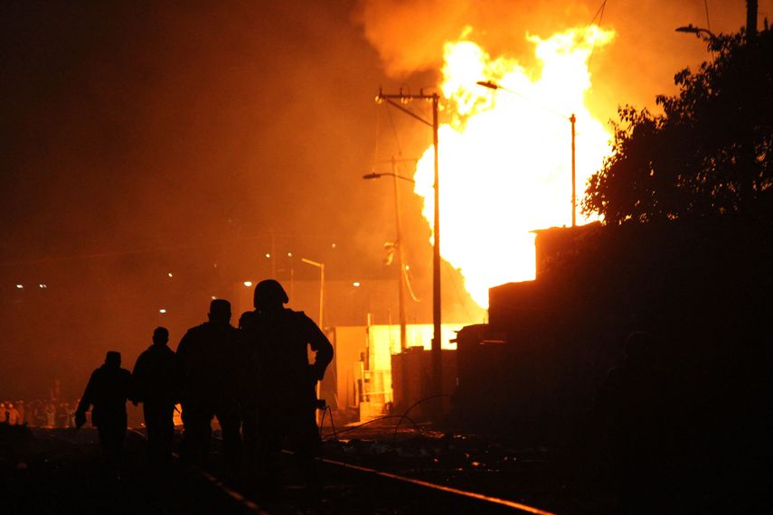 Bomberos trabajan para extinguir el incendio en el lugar de un incendio masivo luego de la explosión de un oleoducto clandestino en Puebla