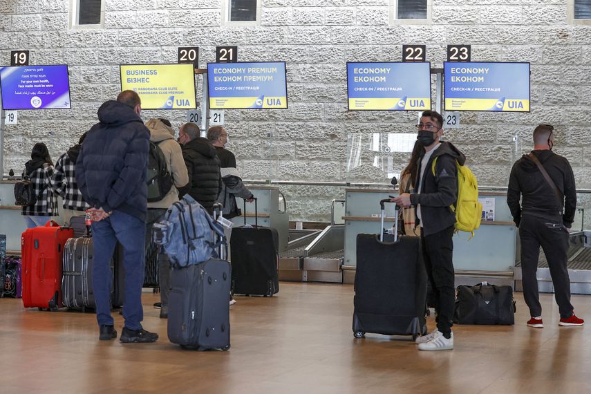 Los viajeros esperan en el mostrador de facturación antes de su vuelo de Ukraine International Airlines (UIA) a Kiev en el aeropuerto Ben Gurion de Israel.