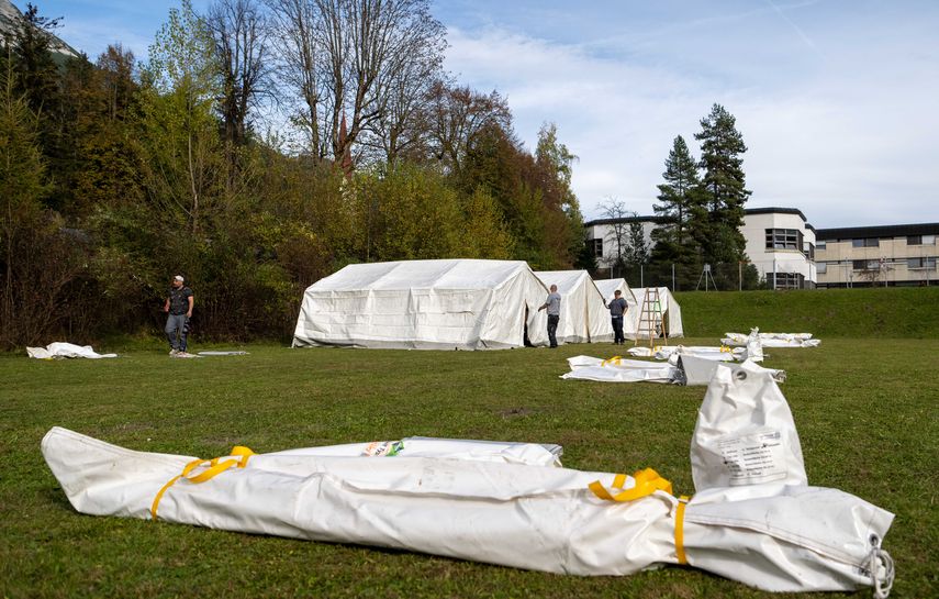 Trabajadores construyendo tiendas de campaña para albergar refugiados en las instalaciones de la escuela de policía Wiesenhof en Absam