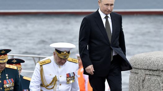 El presidente de Rusia, Vladimir Putin, camina con el comandante en jefe de la Armada rusa, el almirante Nikolai Yevmenov, mientras participa en el desfile naval principal que marca el Día de la Armada Rusa, en San Petersburgo.