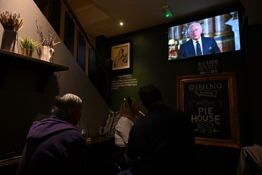 Comensales de un pub de Londres escuchan el primer discurso del rey Carlos III.