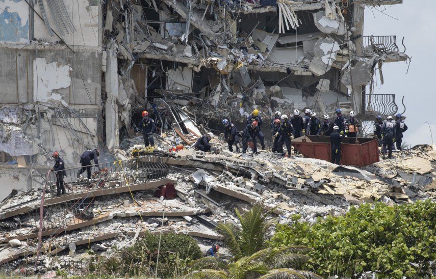 Miembros del equipo de Búsqueda y Rescate Urbano del Sur de Florida buscan posibles sobrevivientes en el edificio de condominios Champlain Towers South de 12 pisos parcialmente derrumbado.