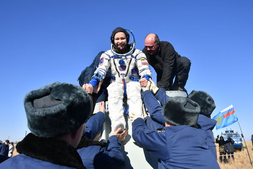 La actriz Yulia Peresild recibe ayuda para desembarcar después del aterrizaje de la cápsula espacial rusa Soyuz MS-18 en un área remota al sureste de Zhezkazgan en la región de Karaganda de Kazajstán.