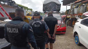 Unidades de la Policía Nacional trasladando a uno de los aprehendiso en el taller Unidades de la Policía Nacional trasladando a uno de los aprehendiso en el taller