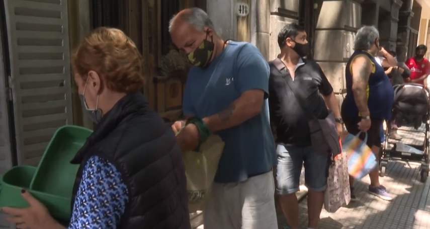 Argentinos acuden a comedores populares para recibir comida.