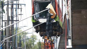 Bomberos y operarios del área de emergencias trabajan para retirar uno de los vagones del Metro que colapsaron en la noche de este lunes en México.