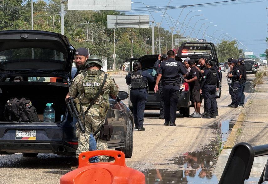 Integrantes del Ejército de México y policías estatales revisan vehículos.