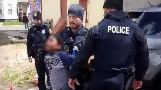 El vídeo, grabado por un transeúnte, muestra a un agente sujetar desde atrás al niño por los brazos.
