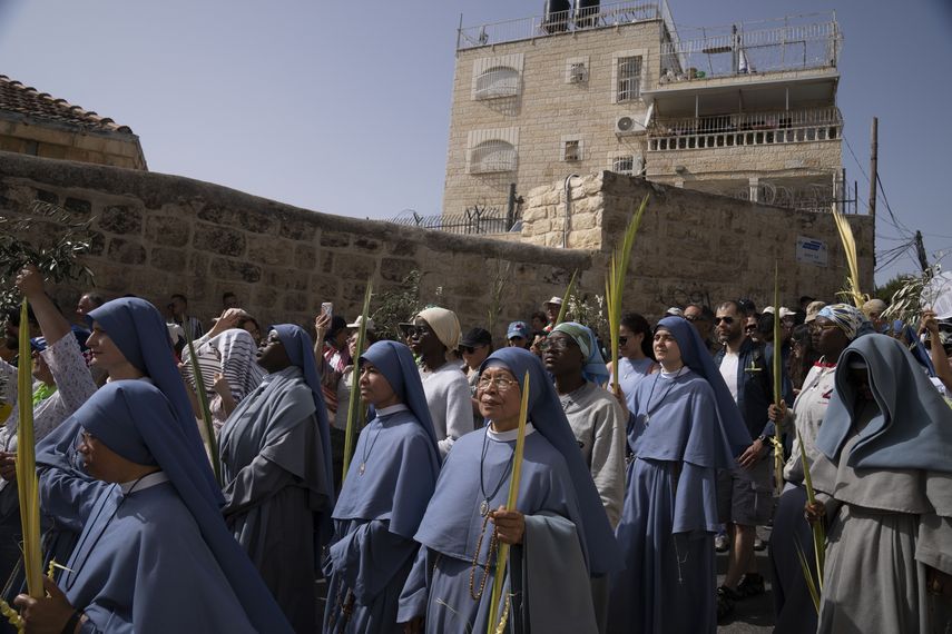 Los fieles llevaban hojas de palma y ramas de olivo mientras marchaban de la cima del Monte de los Olivos a la Ciudad Vieja de Jerusalén.