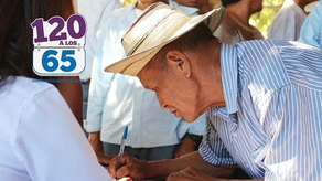 Adulto mayor firmando para recibir el pago del programa 120 a los 65 del MIDES
