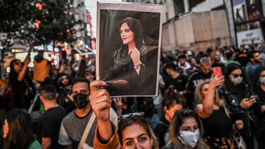 Un manifestante sostiene un retrato de Mahsa Amini durante una manifestación en apoyo de Amini, una joven iraní que murió después de ser arrestada en Teherán por la policía moral de la República Islámica.