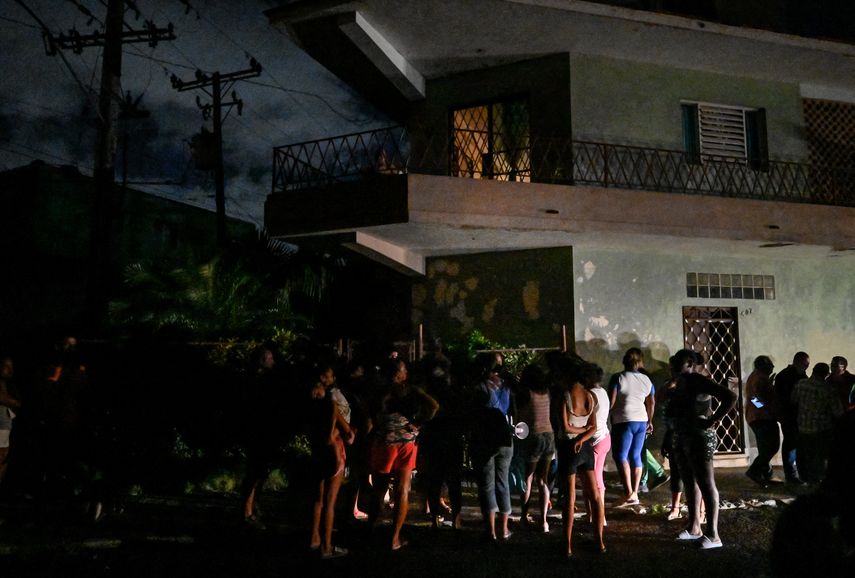 Los residentes se reúnen afuera en un vecindario en medio de un apagón eléctrico prolongado después del huracán Ian en La Habana.
