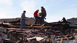 La gente observa los daños causados por un tornado en Mayfield, Kentucky.
