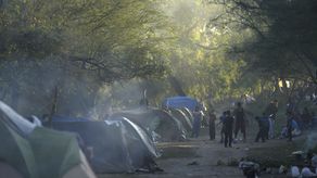 Docenas de migrantes pasan las noches en la rivera de concreto del río a la espera de algún aviso sobre un posible cambio a las restricciones al asilo impuestas en marzo de 2020.