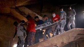 Los trabajadores de rescate llevan un cuerpo recuperado de un edificio después de que estallara un incendio en una fábrica de productos químicos en Karachi, Pakistán.
